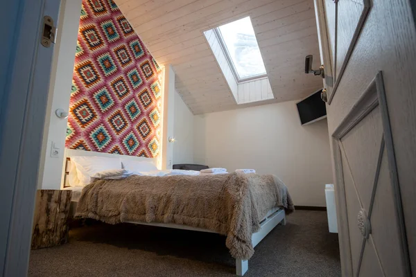 大きなダブルベッドで新鮮なリネンと屋根裏部屋の床に広々としたホテルのベッドルームのインテリア 現代的な家の中の居心地の良い現代的なマンサードルーム — ストック写真