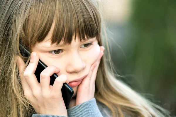 携帯電話で長い髪を話すストレスの子供の少女の肖像画 小さな女性の子供がスマートフォンを使って通信しています 子どものコミュニケーションコンセプト — ストック写真