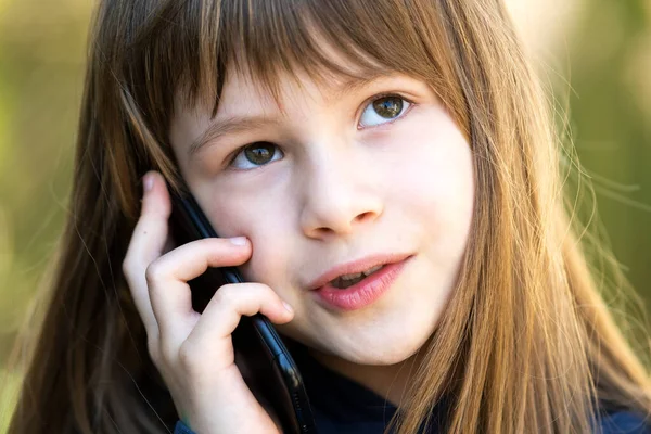 携帯電話で長い髪の少女の肖像画 小さな女性の子供がスマートフォンを使って通信しています 子どものコミュニケーションコンセプト — ストック写真