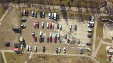 Kirli yüzeyi ve park halindeki bir sürü arabası olan eski otoparkın yukarıdan görünüşü..