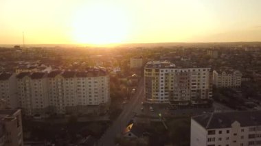 Gün batımında bir şehirdeki konut binalarının havadan görüntüsü.