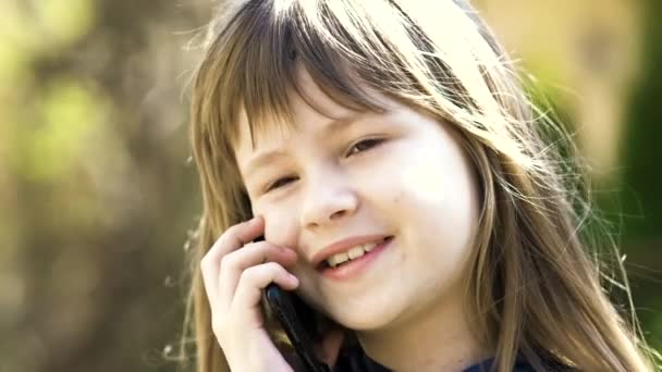 携帯電話で長い髪の少女の肖像画 小さな女性の子供がスマートフォンを使って通信しています 子どものコミュニケーションコンセプト — ストック動画