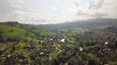 Yazın Ukrayna 'nın Ukrayna Dağları' ndaki yeşil yaz tepeleri arasında küçük bir köyün havadan görünüşü.