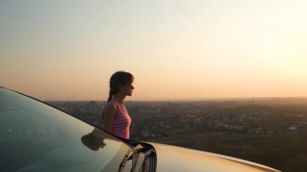 Νεαρή Γυναίκα Στέκεται Κοντά Στο Αυτοκίνητό Της Απολαμβάνοντας Ζεστή Θέα — Αρχείο Βίντεο