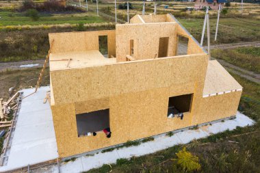 Yeni ve modern modüler evin inşaatı. İçinde köpük yalıtım malzemesi olan kompozit ahşap panellerden yapılmış duvarlar. Yeni enerji tasarruflu ev kavramı oluşturuluyor.
