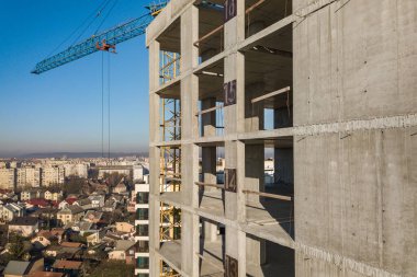 Bir şehirde inşaat halindeki yüksek apartmanın beton çerçevesinin havadan görünüşü.