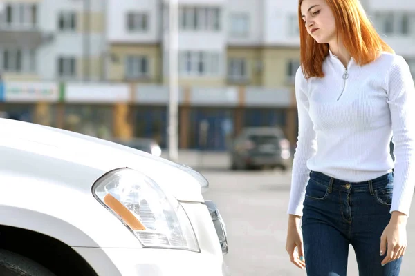 Young stressed woman driver near broken car having a prbreakdown problem with her vehicle waiting for assistance.