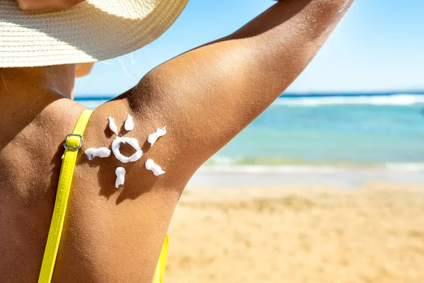 Vista Posterior Una Mujer Joven Bronceándose Playa Con Protector Solar —  Fotos de Stock