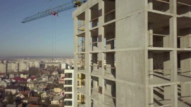 Bir şehirde inşaat halindeki yüksek apartmanın beton çerçevesinin havadan görünüşü.