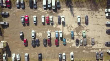 Kirli yüzeyi ve park halindeki bir sürü arabası olan eski otoparkın yukarıdan görünüşü..