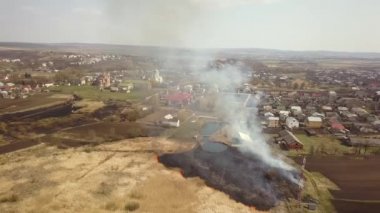 Kuru otların yandığı, turuncu alevler ve yüksek dumanlı bir arazinin havadan görünüşü..