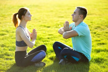 Sıcak yaz günlerinde yoga egzersizleri yapan genç bir çift..