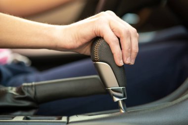 Otomatik vites kolunda elini tutan kadın sürücünün yakın çekim görüntüsü..