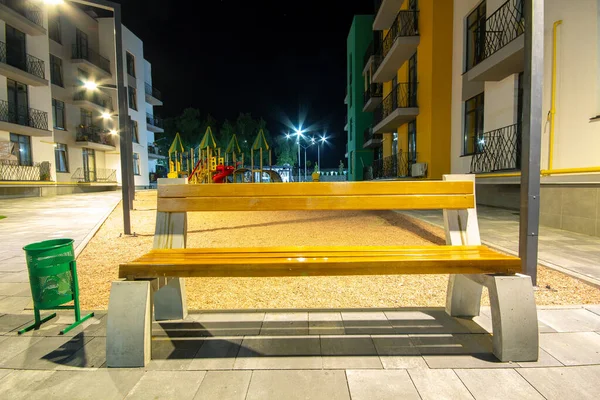 Boş ahşap bank ve modern apartman daireleri arasındaki avluda. Gayrimenkul geliştirme.