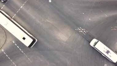 Şehir trafiğinin yukarıdan aşağıya bakan görüntüsü, kavşaktaki bir caddede hareket halindeki arabalar..