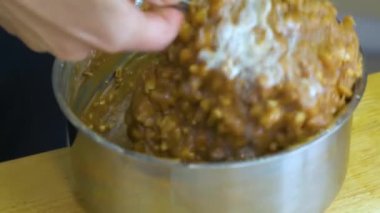 Kadın ellerine yakın durun. Fıstık hazırlıyorlar. Pasta için bir kase dolduruyorlar..