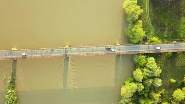 绿色农村地区泥泞宽阔河流上一座狭窄桥梁的空中景观 — 图库视频影像