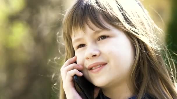 携帯電話で長い髪の少女の肖像画 小さな女性の子供がスマートフォンを使って通信しています 子どものコミュニケーションコンセプト — ストック動画