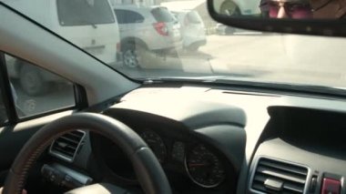 Güneşli bir günde şehir caddesinde direksiyon başında araba süren kadın elleri yakın çekim görüntüsü..