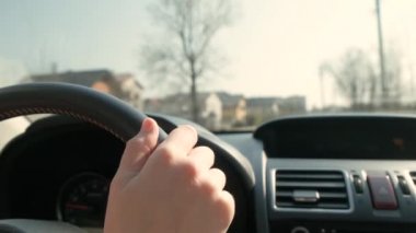 Güneşli bir günde şehir caddesinde direksiyon başında araba süren kadın elleri yakın çekim görüntüsü..