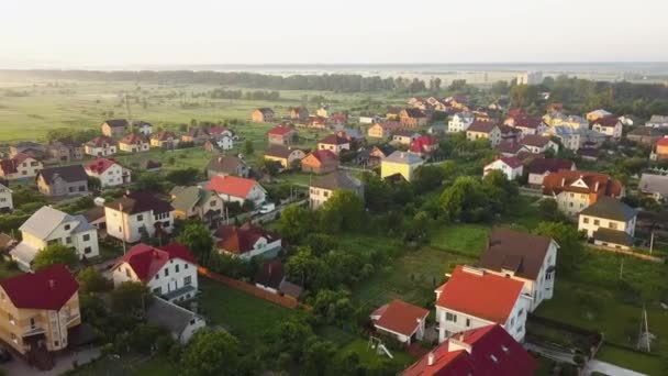 日の出時に緑のフィールドの間の民間住宅と農村住宅地域の空中ビュー — ストック動画