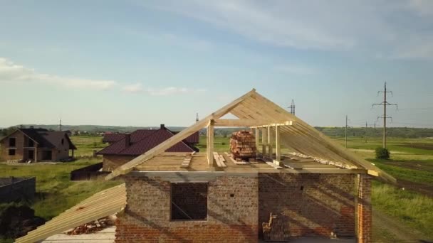 Aerial view of unfinished brick house with wooden roof frame structure under construction. — Stock Footage Aerial View Unfinished Brick House Wooden Roof Frame Structure Construction Stock Video