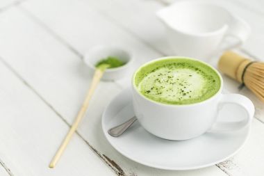 Yeşil çay matcha latte Kupası ile boşaltmak.