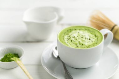 Matcha latte Kupası kapatın arka plan bulanık.