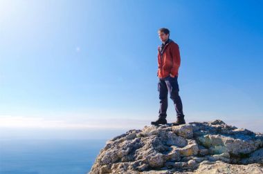 Rock dağın zirvesinde ayakta adam. Gün ışığı