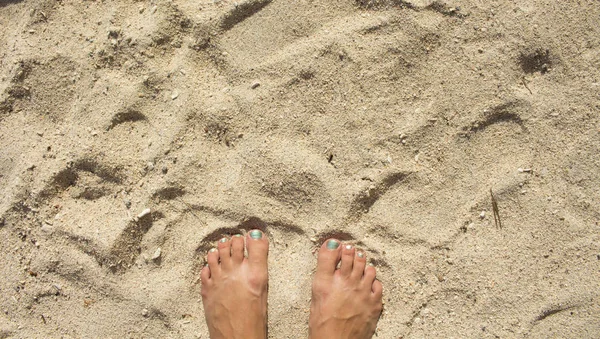 Weißer Sandstrand und weibliche Füße. Weicher Sand Strand Draufsicht Foto für Hintergrund oder Vorlage — Stockfoto