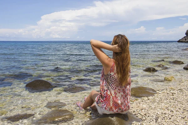 Женщина и море. Молодая рыжая женщина, сидящая у моря на пляже. S — стоковое фото