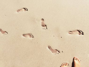 Ayak adım deniz güneşli kum plajı üzerinde işaretler; Yaz seyahat fotoğraf