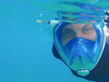 Maske mavi su kadında. Tam yüz maskesi içinde şnorkel kız.