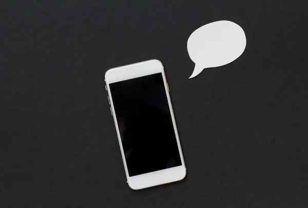 Téléphone blanc avec bulle de parole vierge sur fond noir . — Photo