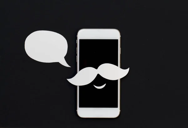 White phone with cartoon text bubble and smile. Smartphone in mustache paper cut collage with speech bubble. Creative cellphone banner template with text place. Smiling Iphone in hipster style photo