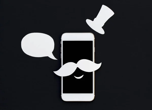 Téléphone blanc avec bulle de texte de dessin animé et sourire. Smartphone en moustache et chapeau vintage . — Photo