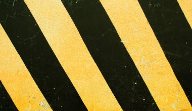 Tehlikeli yol işaret. Beton taş doku üzerinde siyah ve sarı şeritler. Tehlikeli şekilde kavramı. Yılan gibi yol kenarı dur. Tehlike karayolu üzerinde. Emniyetli sürücü hatırlatma. Kaba doku sarı siyah boya