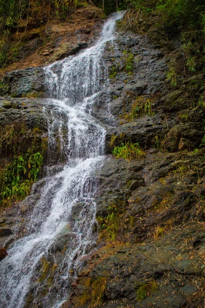 Tall waterfall on mountain. Waterfall stream detailed photo