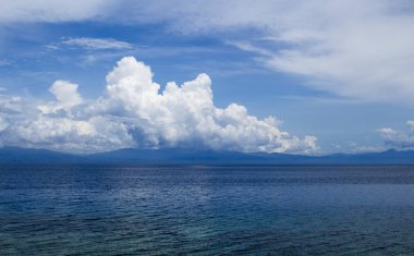 Bulutlar ile deniz Panoraması. Bulutlu deniz manzarası. Tropikal sahil minimal fotoğraf. Ufukta Cumulus ile romantik deniz. Tropikal iklim veya hava durumu. Tropikal ada manzarası. Deniz suyunda bulut yansıması
