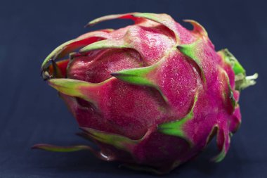 Egzotik meyve Dragonfruit siyah arka plan üzerine pembe ve yeşil deri ile. Canlı egzotik meyve banner şablon. Dragon meyve veya pitahaya studio fotoğraf. Tatlı tropikal meyve. Bütün Konfit pitahaya portre