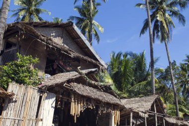 Dumaguete, Filipinler - 1 Kasım 2017: Yerel dekorasyonu ile Hediyelik eşya dükkanı. Kuru yaprak çatı rustik kabile ev. Turistik Hediyelik Dükkanı giriş dış. Palmiye ağaçları altında basit ev. Tatil tropikal