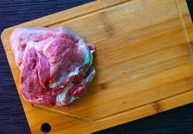 Et parçası üzerinde ahşap tahta kesmek. Mutfak Masa üstten görünüm fotoğraf. Çiğ et yemek için hazırlanıyor. Sığır eti veya domuz fileto portre. Biftek Tarifi veya pişirme kitap görüntü. Et yemek için seçme. Ahşap cutboard