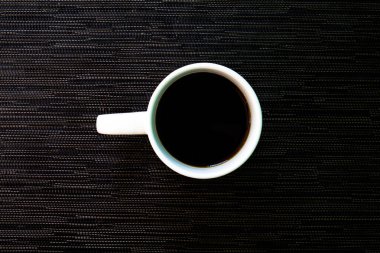 Beyaz fincan kahve siyah arka plan üzerine. Beyaz seramik fincan sade kahve ile. Rustik sabah kahvaltı banner şablon. Enerjik etkisi ile sıcak bir içecek. Cappuccino veya espresso tablo üstten görünüm fotoğrafı