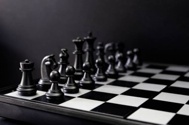 Siyah satranç figürleri gemide. Siyah satranç oyunu başlatmak için sırayla ayarlayın. Siyah satranç figürleri satır kareli tahta üzerinde. Satranç oyunu başlar. Şah mat oyunu banner şablon. Fikri spor. Taktik oyunu
