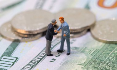 İş adamları oyuncak sallayarak nakit eller. Küçük işadamları figürler para arka plan üzerinde.