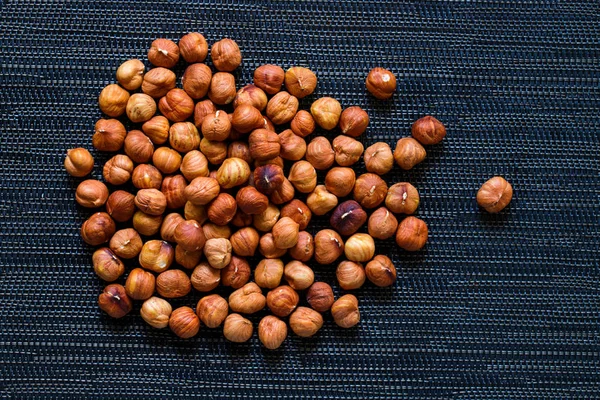 Brown hazelnut heap on dark background. Ripe hazel nut for food