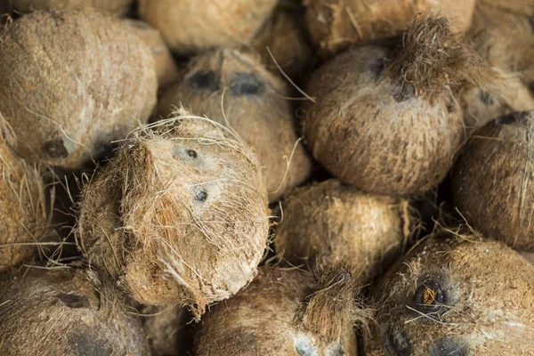 Cocos enteros en la pila foto de primer plano. Fruta exótica o nuez. Cocos peludos marrones en venta —  Fotos de Stock