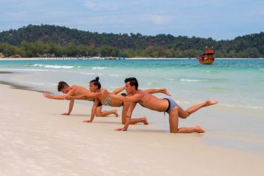 Koh Rong Adası, Kamboçya - 08 Nisan 2018: insanlar yoga üzerinde beyaz kum plaj deniz kenarında.