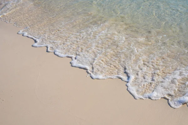 Zee Golf op zand strand fotoachtergrond. Koraal strand zand met zee getij. — Stockfoto