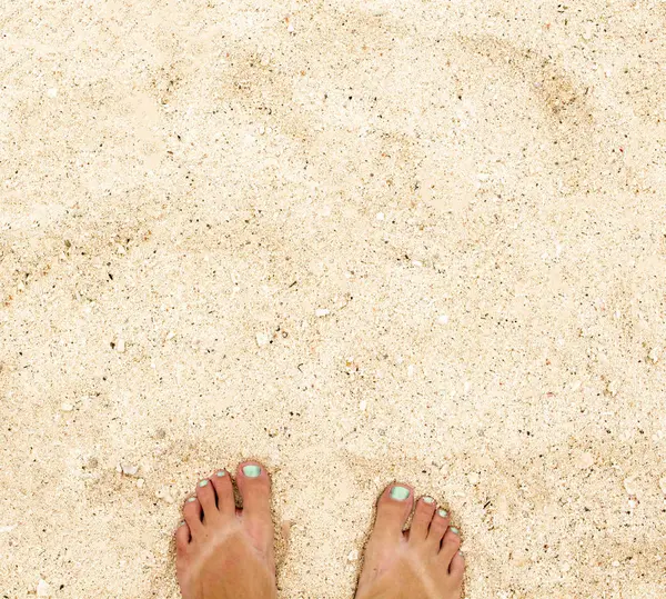 Женские ноги на теплом белом песке. Желтый песок фото сверху — стоковое фото